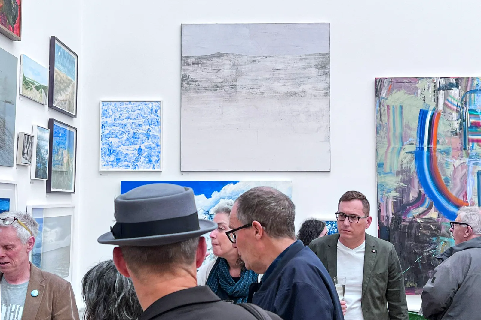 Vizitatori adunați în conversație în fața lucrărilor expuse în timpul Private View de la Royal Academy Summer Exhibition 2024, seara în care lucrarea mea și-a găsit colecționarul