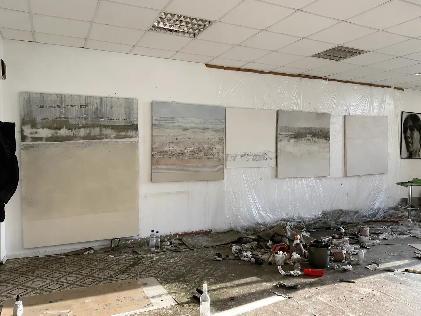 Cinci picturi de peisaj abstractizat, de mari dimensiuni, în lucru, sprijinite pe peretele atelierului una lângă alta, arătând cum se dezvoltă o serie prin repetiție și variație